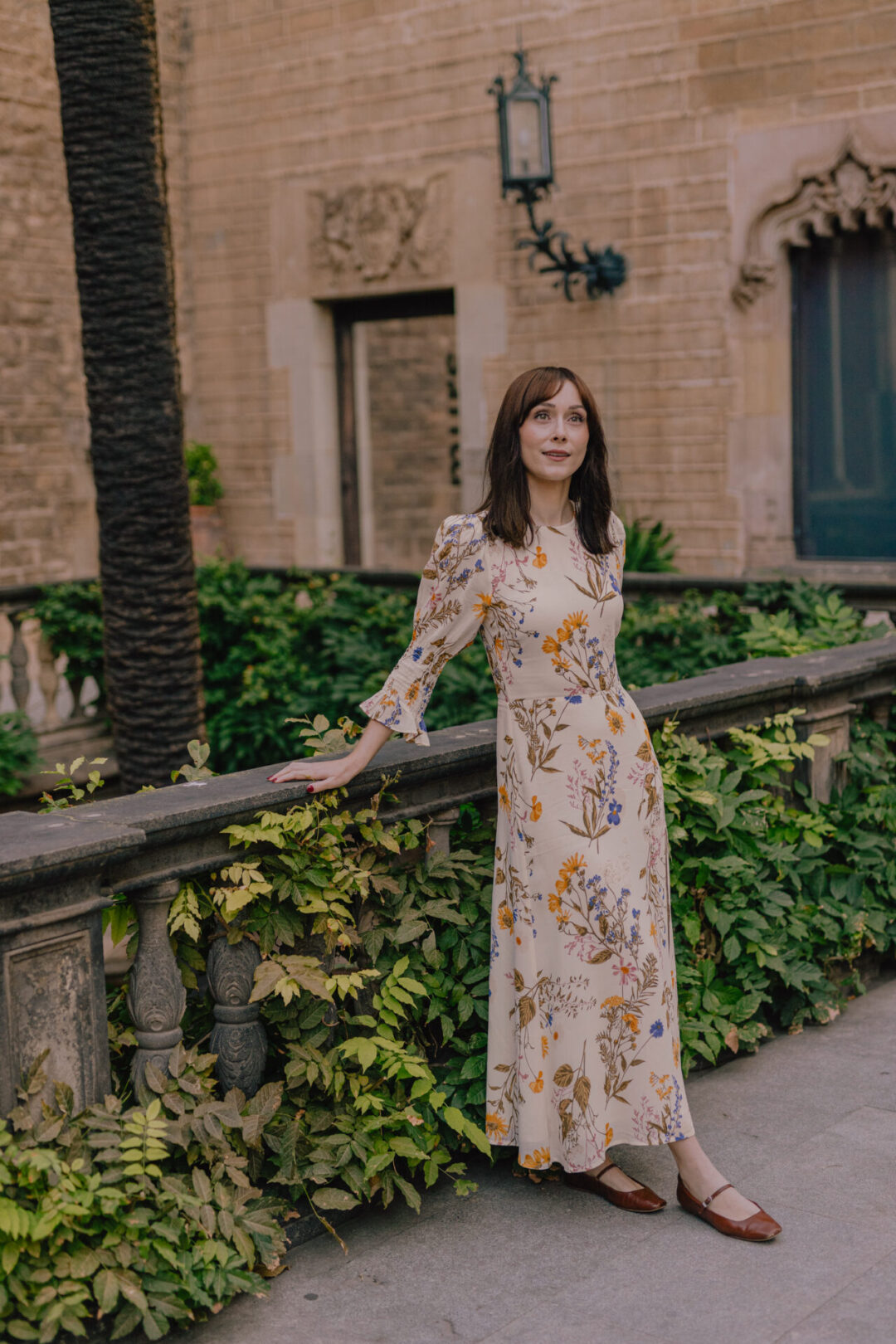 Travel Blogger Jordan Gassner looking up while leaning against a hidden balcony in Barcelona's Old Town