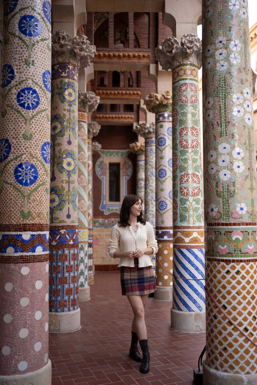 What to Wear in Spain: Travel Blogger Jordan Gassner standing in between the mosaic columns inside Palau de Musica in Barcelona, Spain