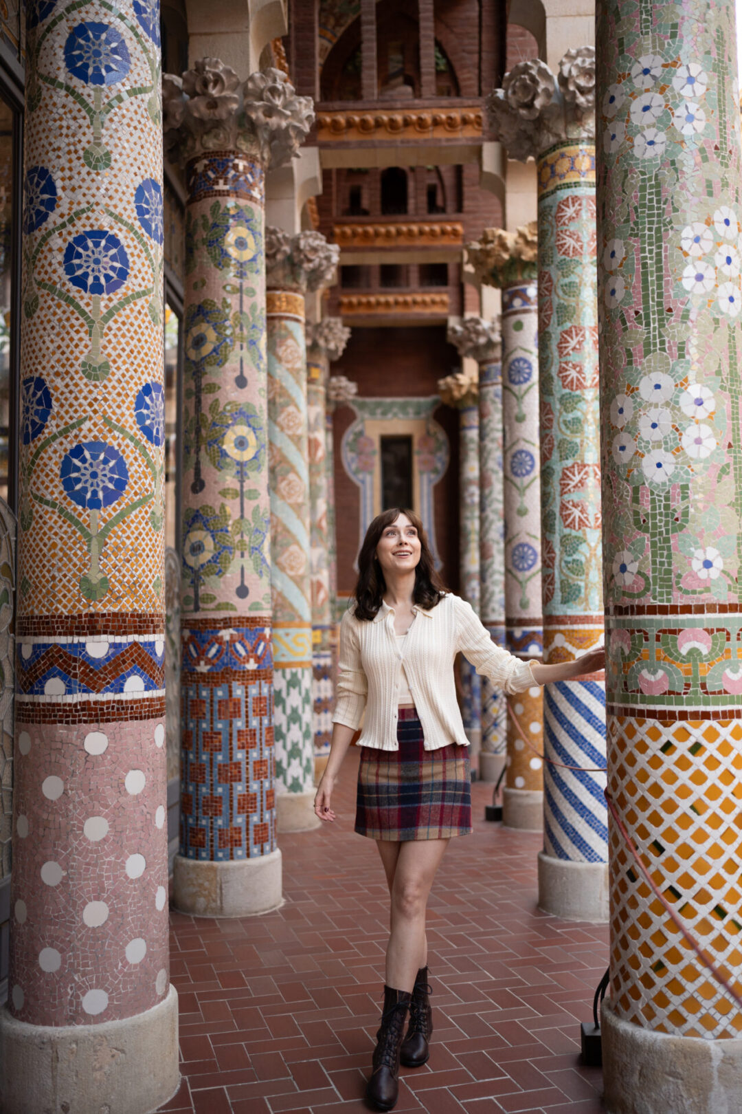 Travel Blogger Jordan Gassner smiling up at the mosaic columns inside Palau de Musica in Barcelona, Spain