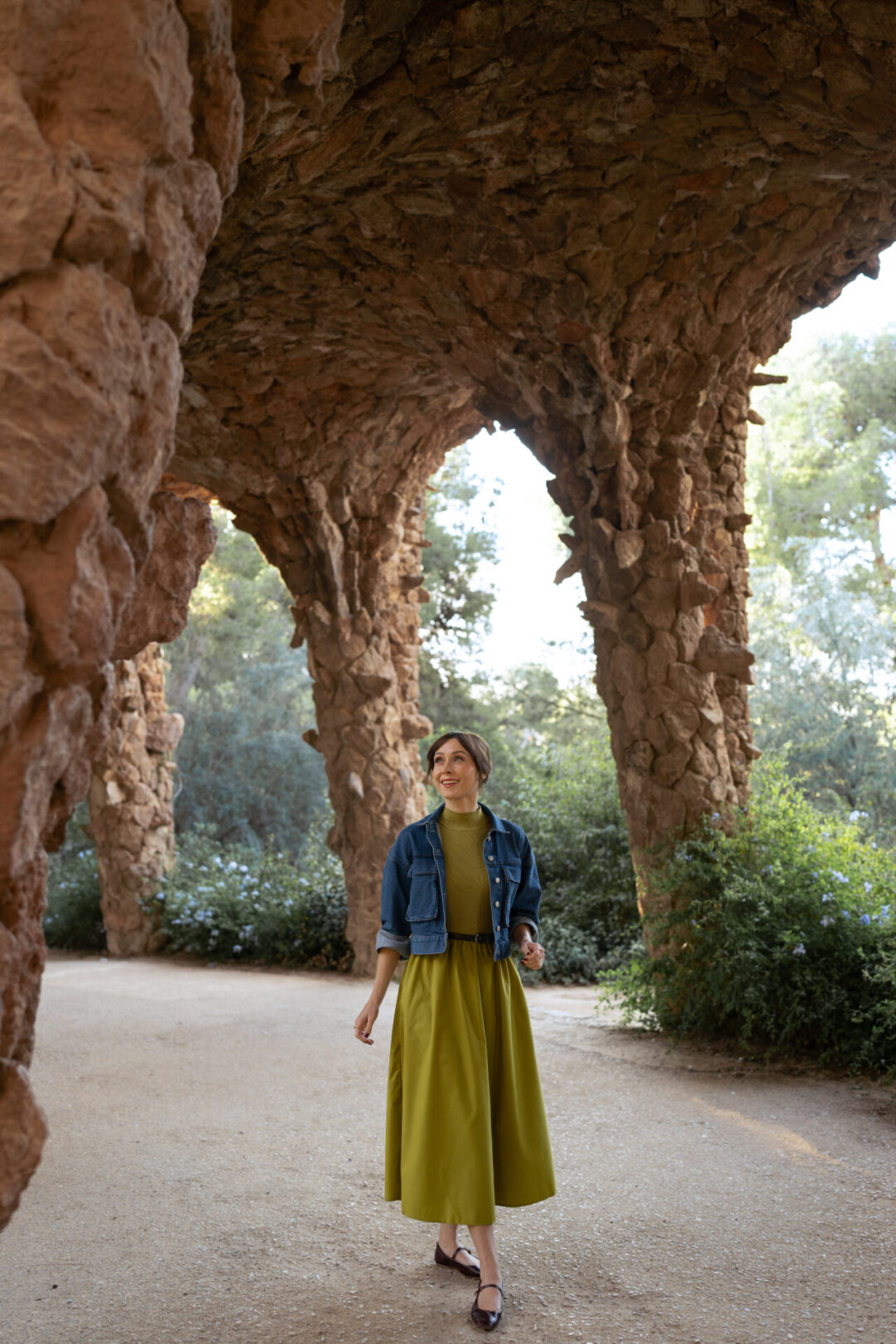 Travel Blogger Jordan Gassner smiling while looking up at the sculptures in Park Guell in Barcelona, Spain