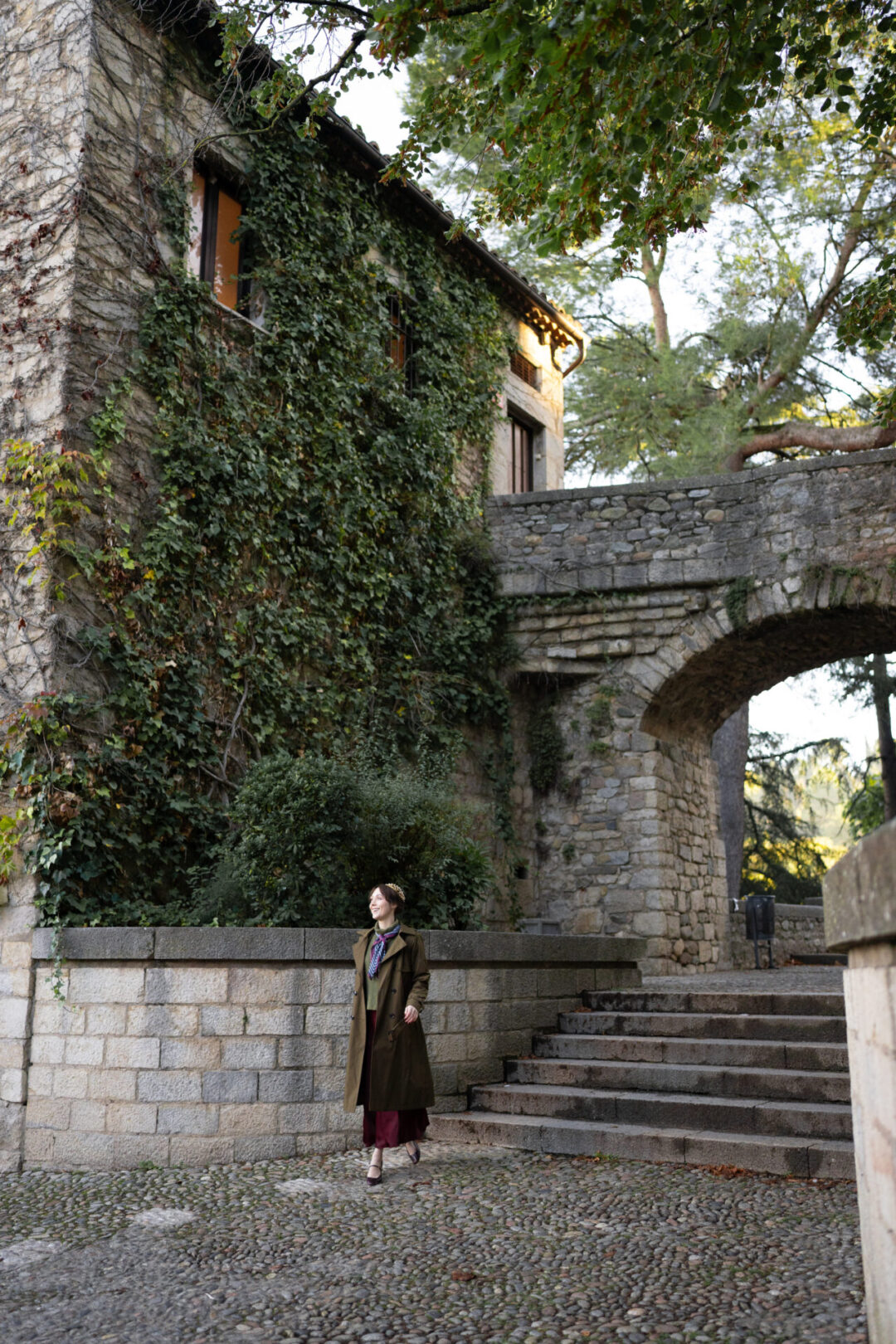 Travel Blogger Jordan Gassner smiling and walking through the medieval old town of Girona, Spain