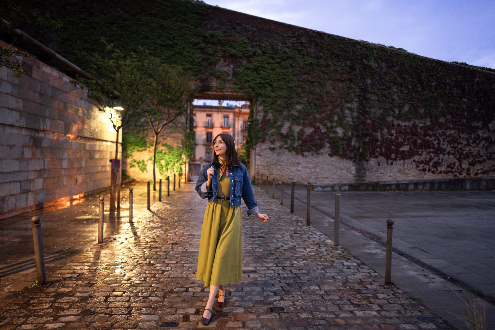 Travel Blogger Jordan Gassner standing on an empty medieval street at twilight in Girona, Spain