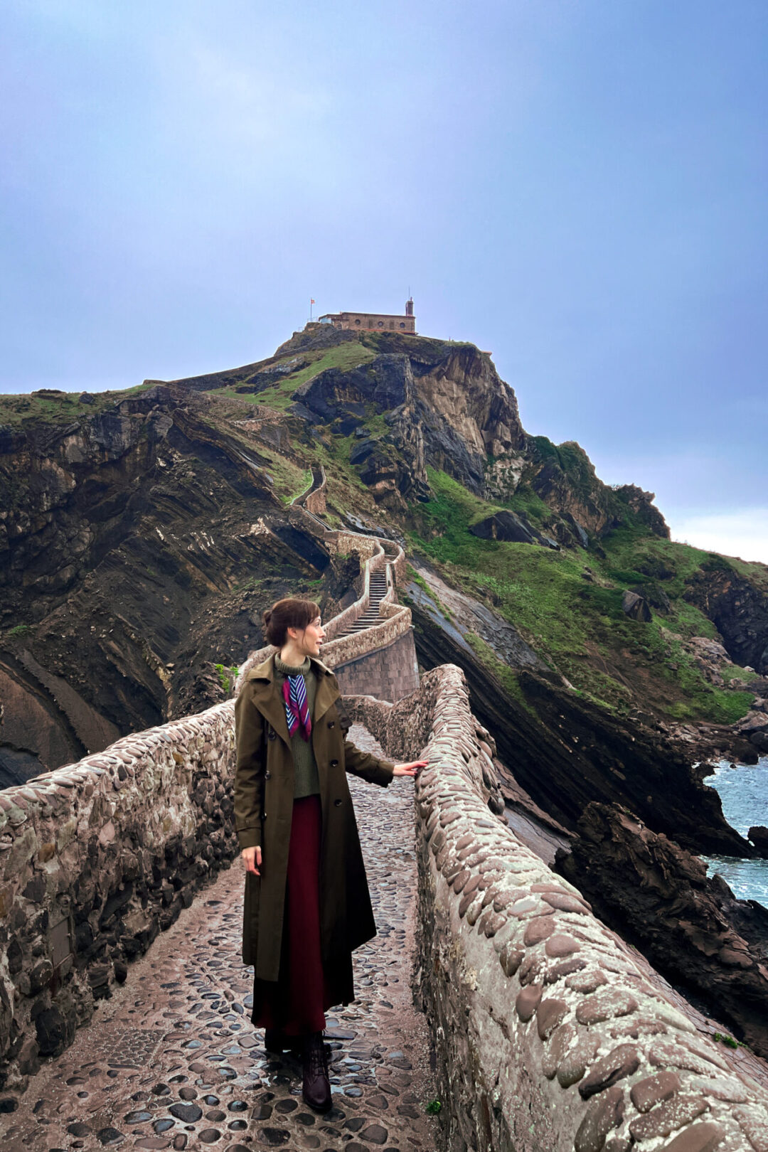 Things to do in Bilbao - Travel Blogger Jordan Gassner looking toward the sea from the stone stairway to San Juan de Gaztelugatxe in Spain