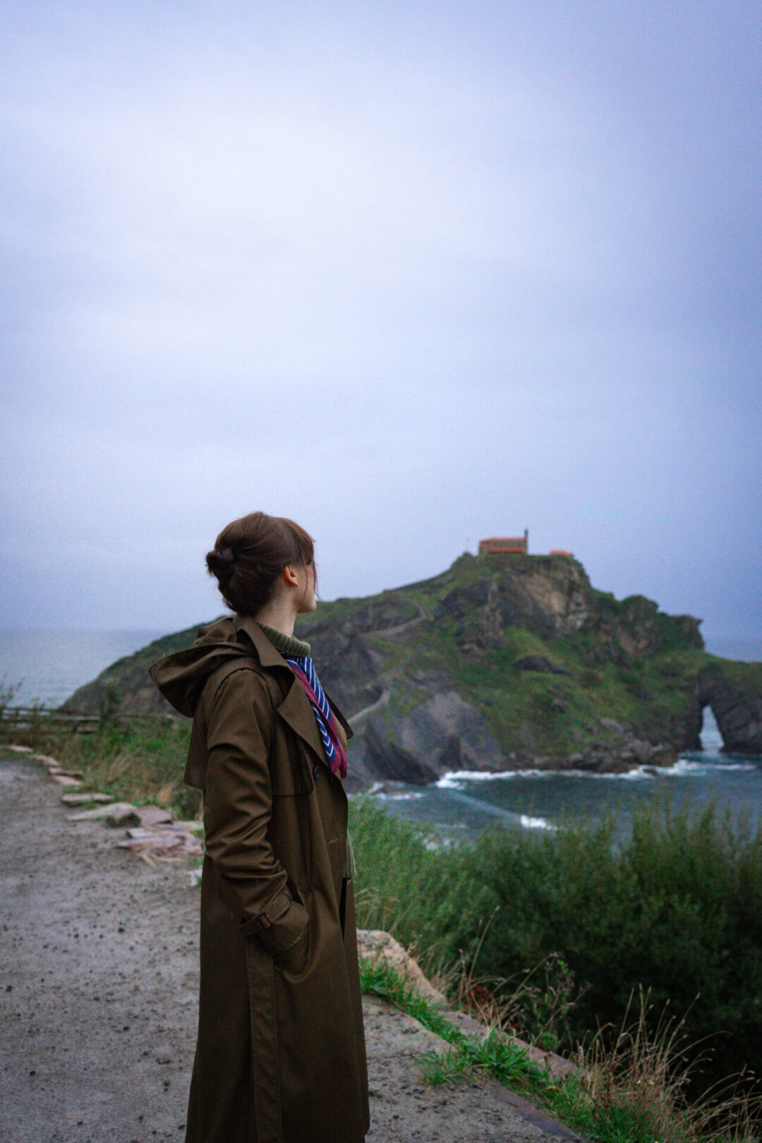 Visiting San Juan De Gaztelugatxe - Travel Blogger Jordan Gassner looking toward San Juan de Gaztelugatxe from a service road along the Basque Coast in Spain