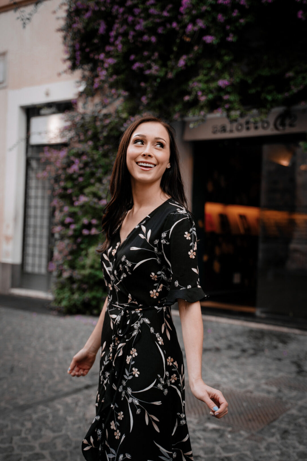 Travel Blogger Jordan Gassner looking over her shoulder and smiling just outside the Salotto42 cocktail bar in Rome, Italy