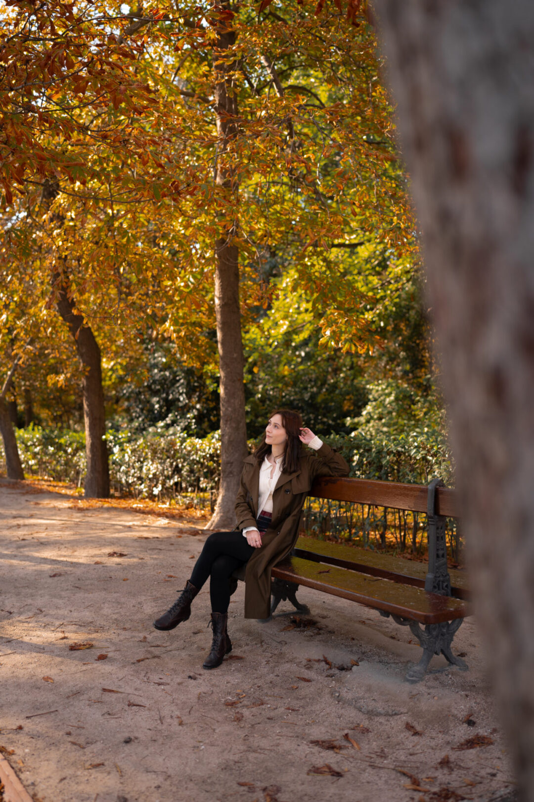 Travel Blogger Jordan Gassner leaning her head against her hand and relaxing on a bench in Retiro Park in Madrid, Spain