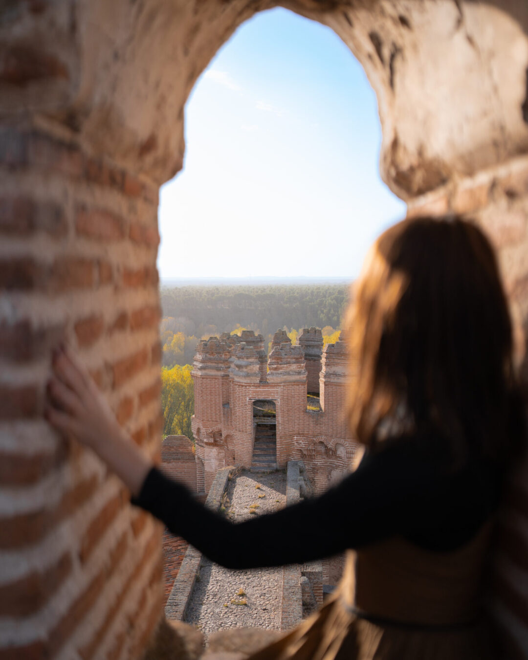 Travel Blogger Jordan Gassner looking out from a window atop Castillo de Coca on a warm autumn day in Spain