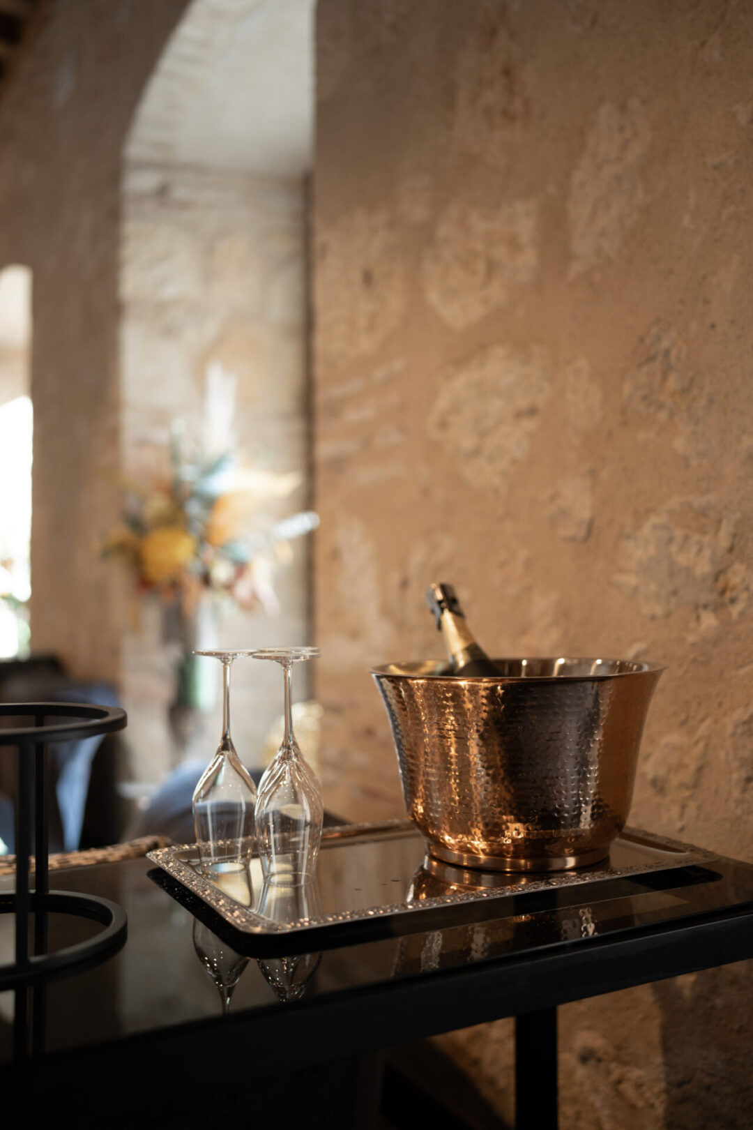 A bottle of champagne in an ice bucket next to two empty glasses in the lobby of Aurea Convento Capuchinos, a hotel in Segovia, Spain