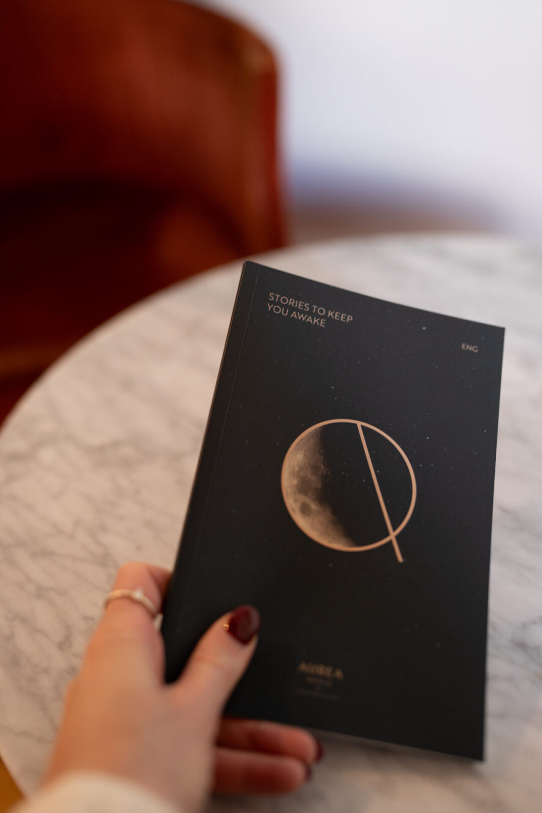 A woman's hand holding a book of bedtime stories from Aurea Convento Capuchinos, a hotel in Segovia, Spain