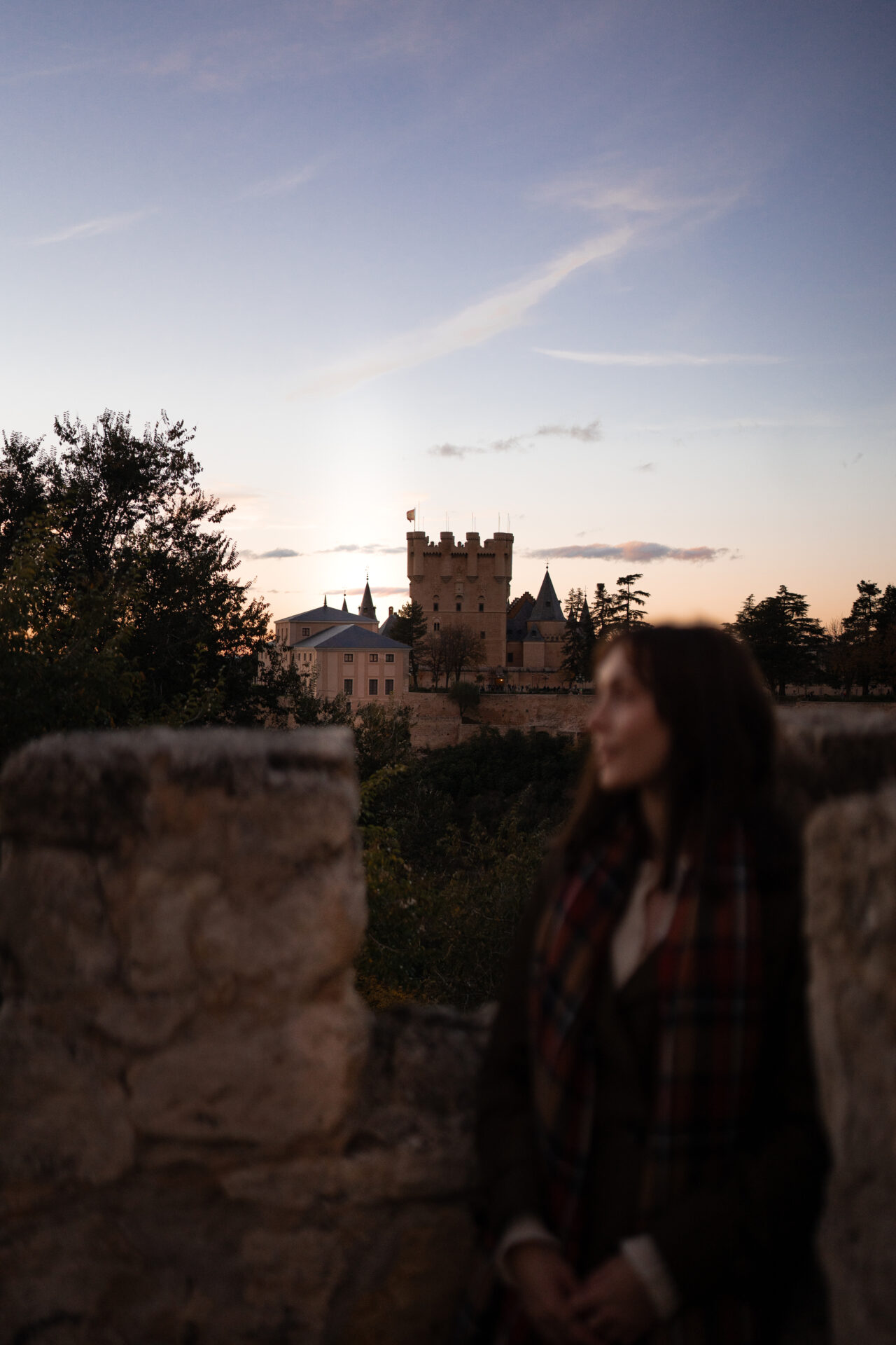 Travel Blogger Jordan Gassner standing at Mirador de la Pradera de San Marcos with a view of the Alcazar in the background in Segovia, Spain