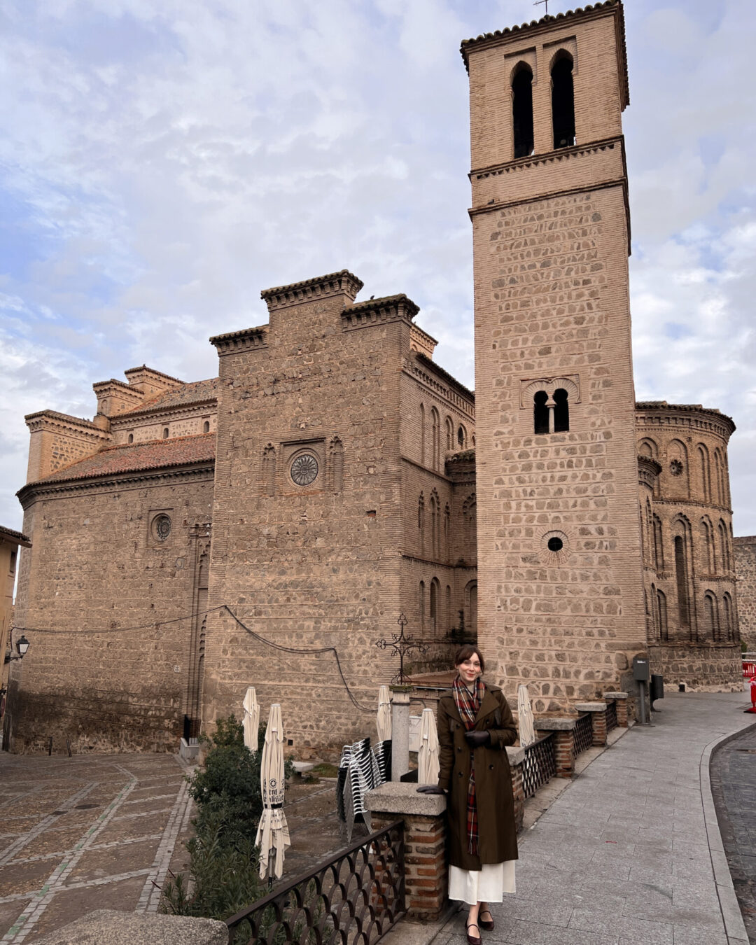 Travel Blogger Jordan Gassner standing on a sidewalk in front of an old church in the Old Town of Toledo, Spain