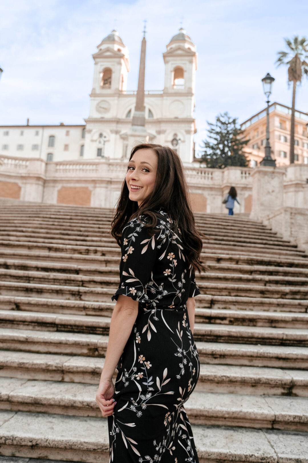 Travel Blogger Jordan Gassner turning around and smiling while climbing the Spanish Steps in Rome