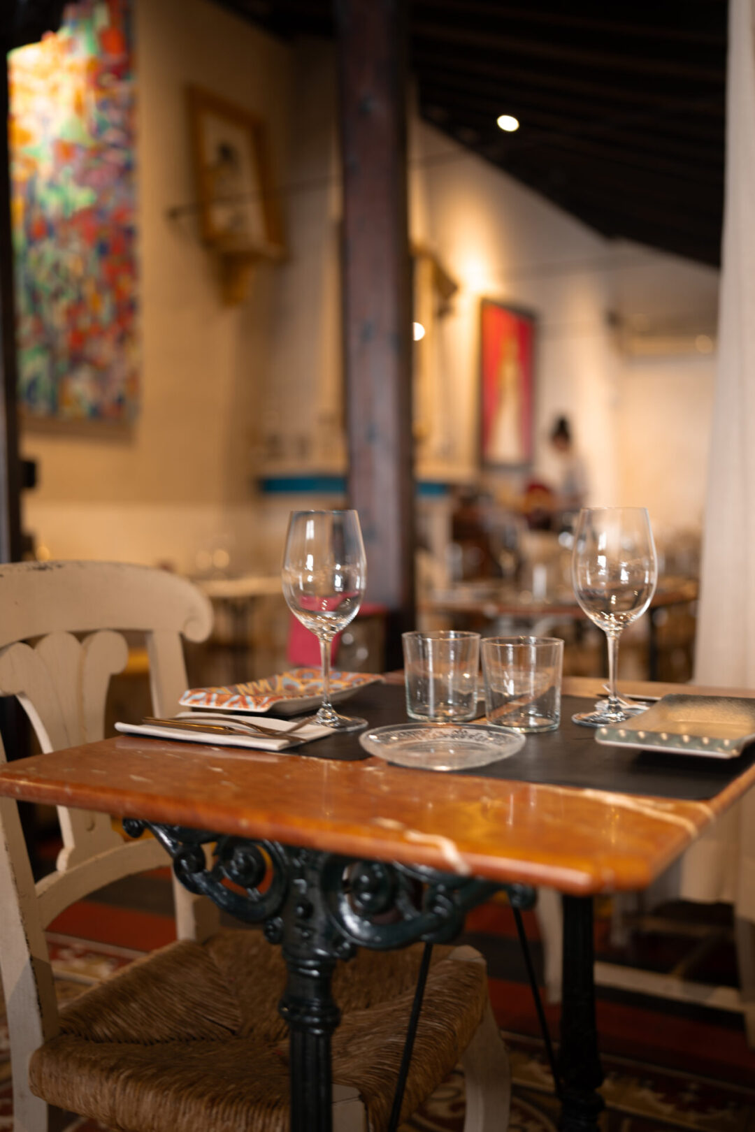 An empty table with wine glasses and plates inside Alfileritos 24, a creative tapas restaurant in Toledo, Spain