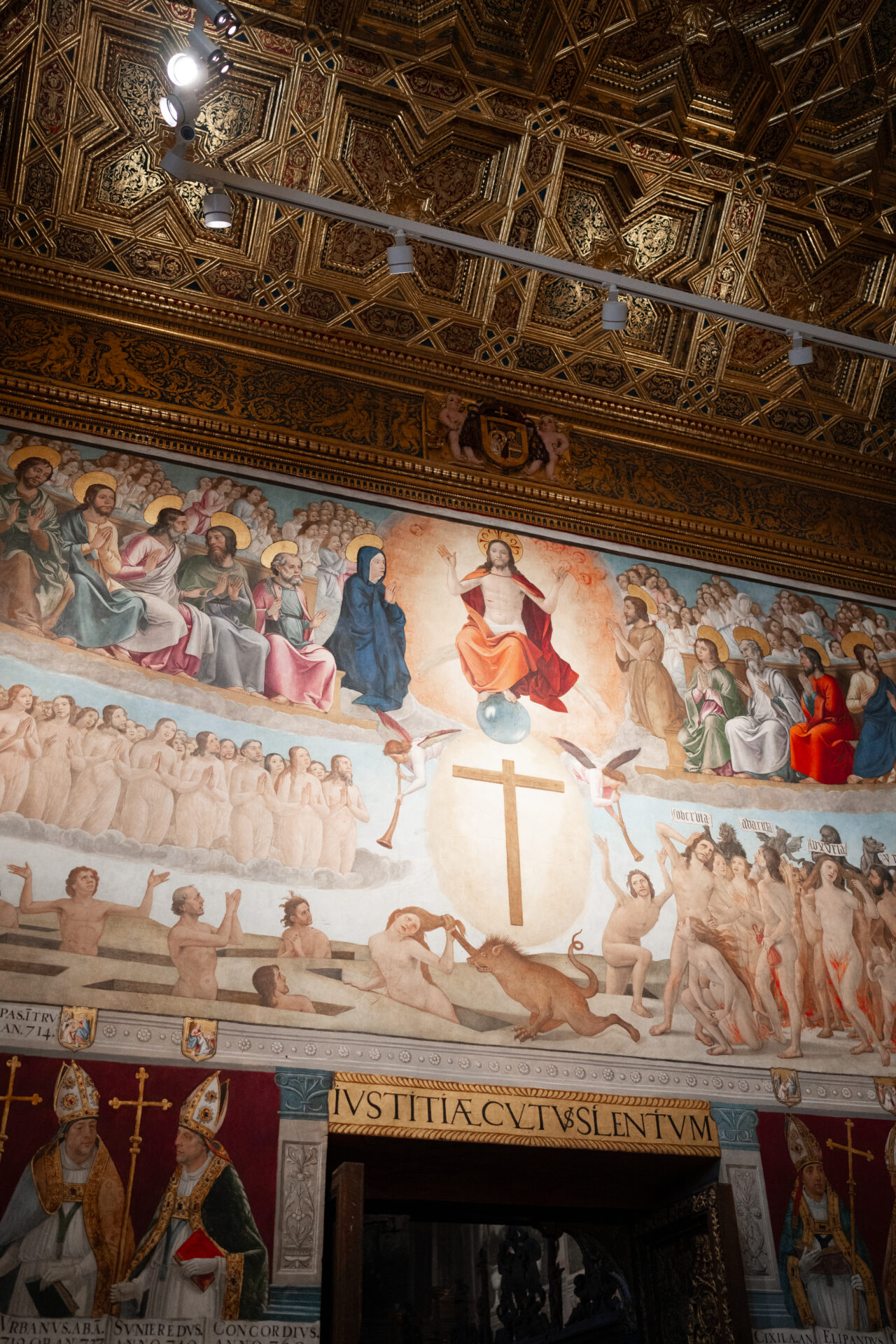 A colorful relief showing Jesus sitting in Heaven above a doorway inside the Toledo Cathedral in Spain