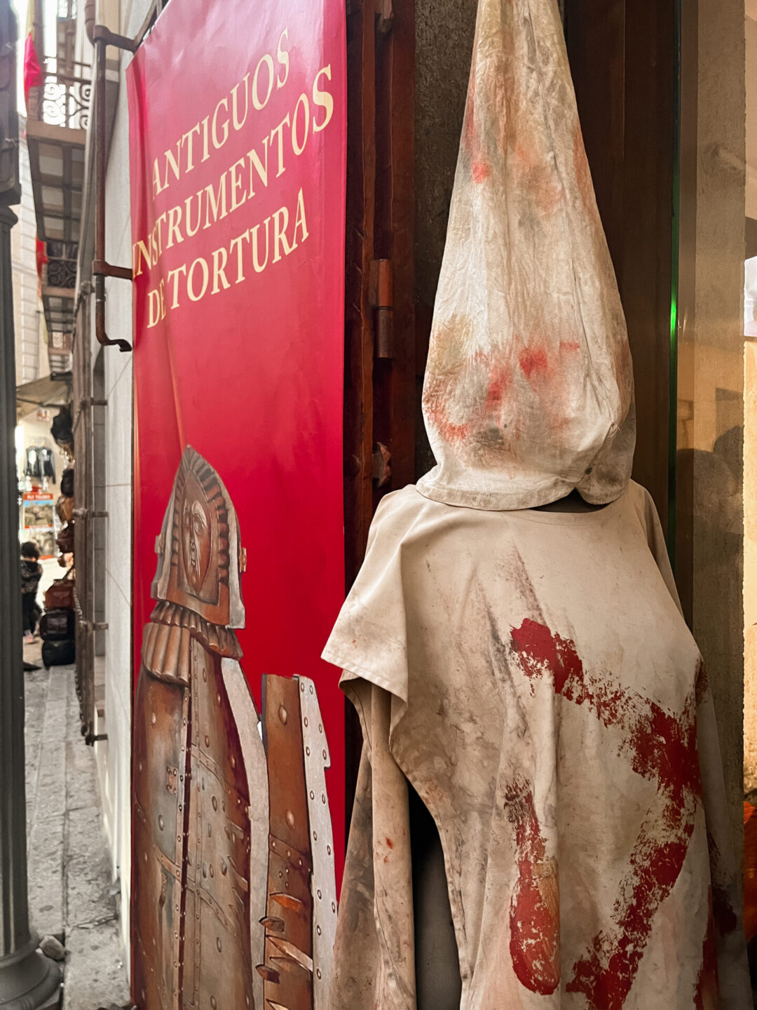 A mannequin covered in a replica medieval torture costume in front of the entrance to the Torture Museum in Toledo, Spain