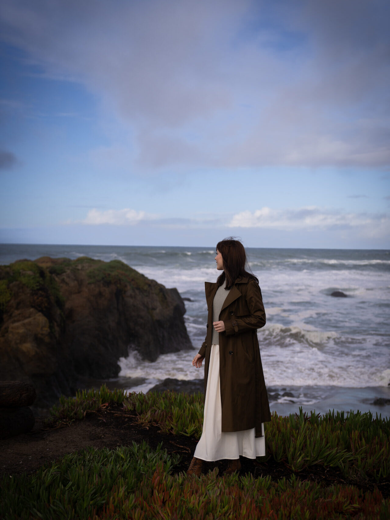Travel Blogger Jordan Gassner looking out toward the ocean on the rocky formations on Glass Beach in Mendocino, California