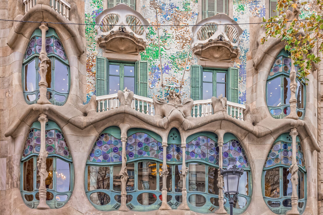 A close-up of a balcony and series of windows on Casa Batllo, built by Antoni Gaudi in Barcelona, Spain