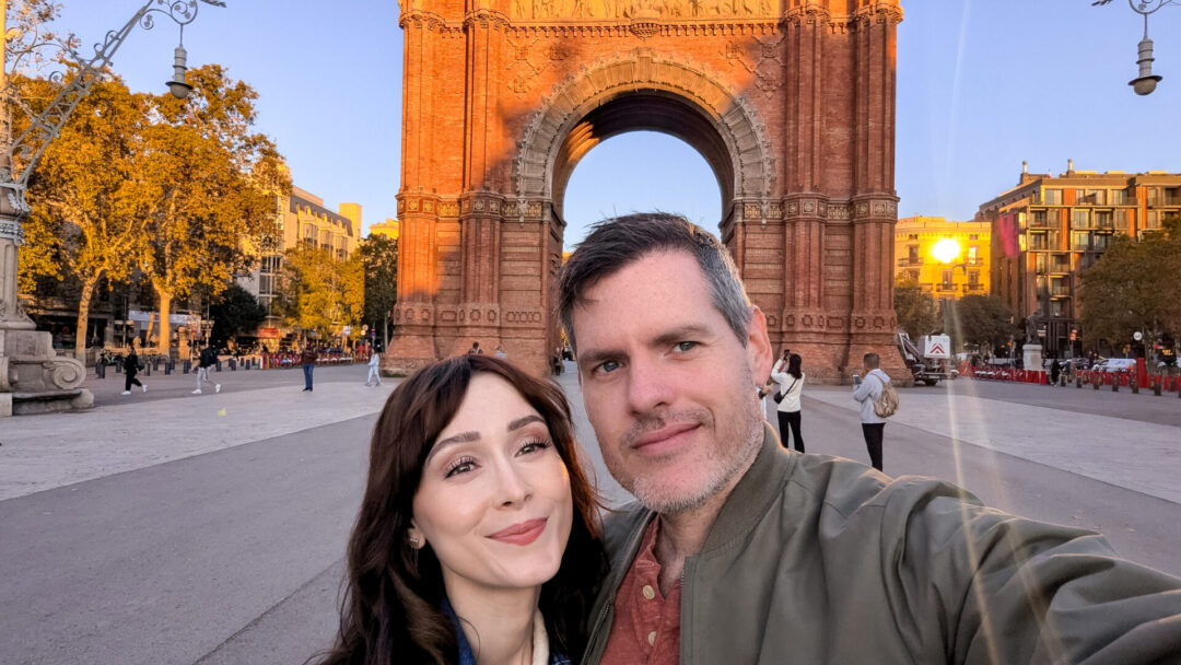 Travel Blogger Jordan Gassner and her partner taking a selfie in front of the Arc de Triomf in Barcelona, Spain