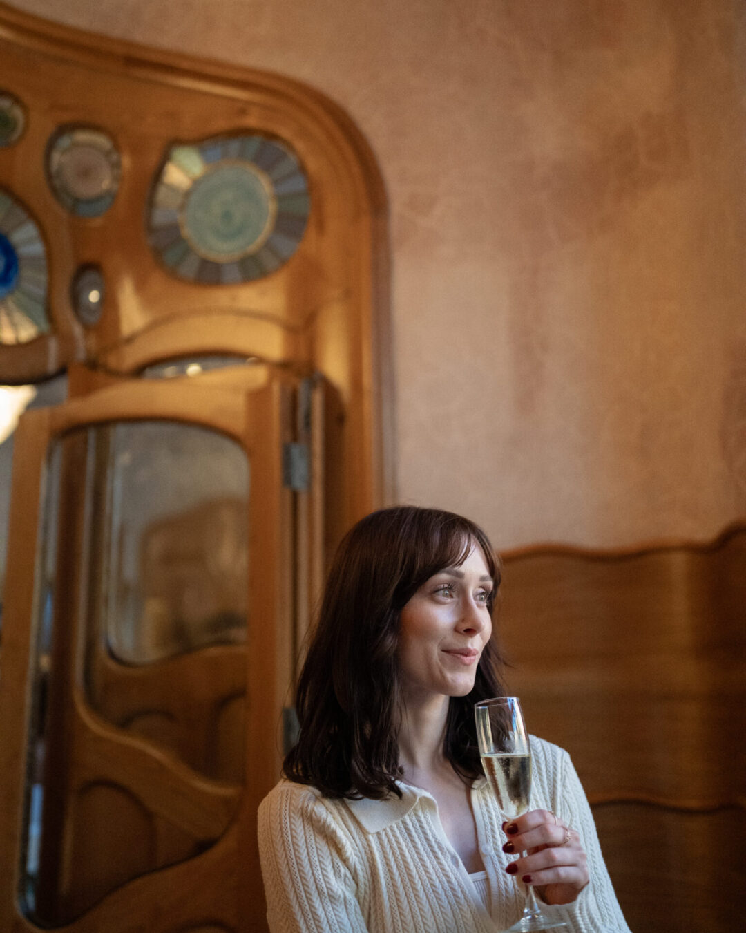 Travel Blogger Jordan Gassner enjoying a glass of cava inside one of the second floor rooms of Casa Batllo in Barcelona, Spain