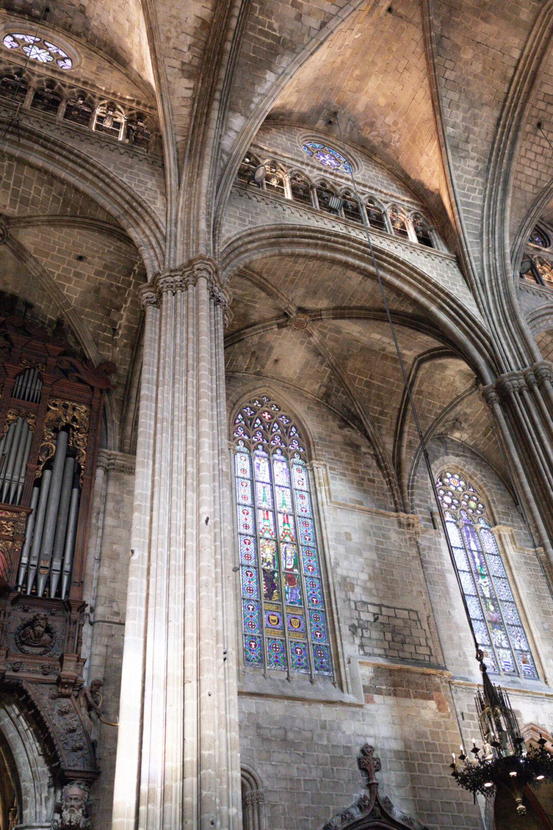 A low angle view o one of the large stained glass windows along the side of the nave in Barcelona Cathedral in Spain