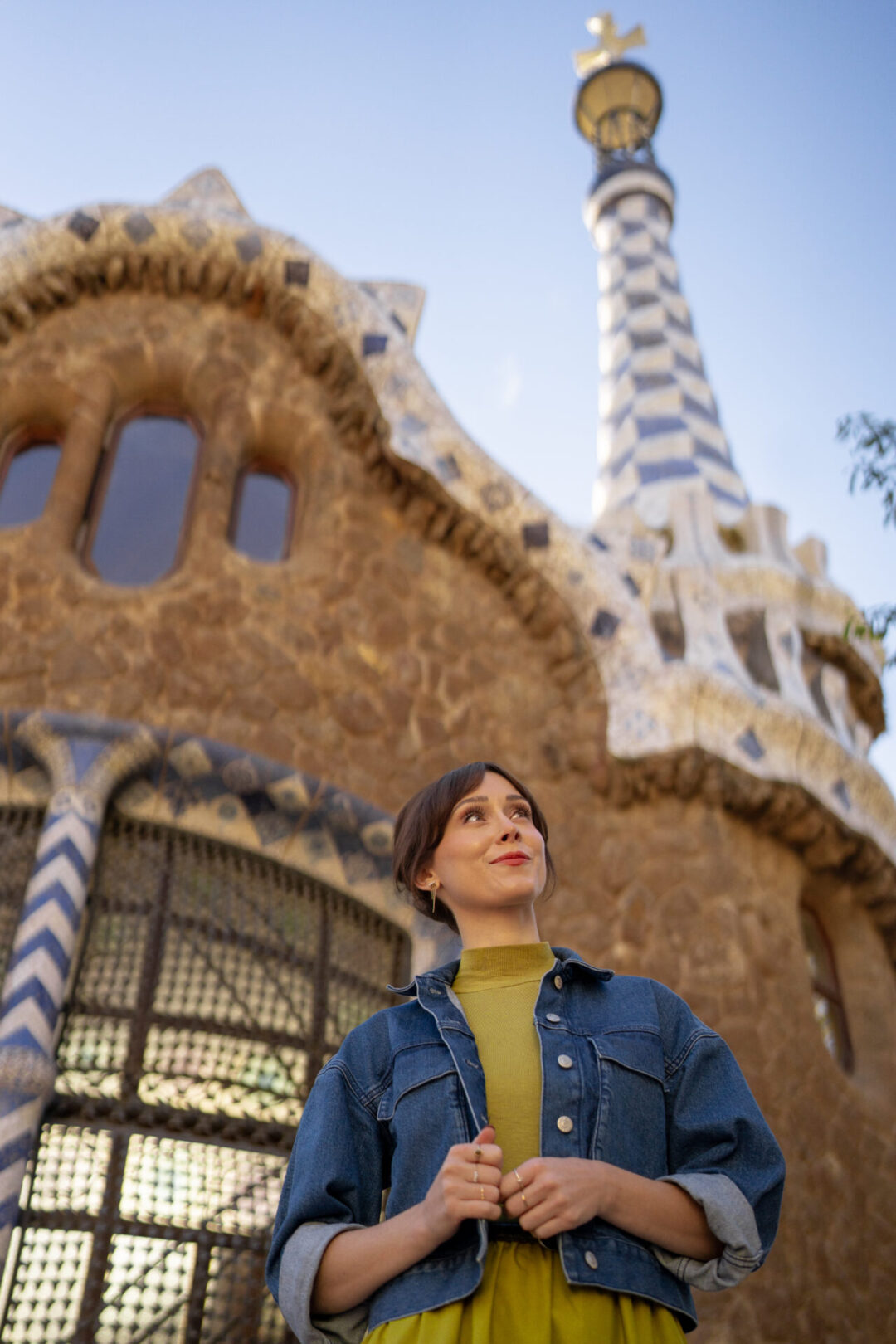 Travel Blogger Jordan Gassner peering up from underneath the entrance building inside Park Guell in Barcelona, Spain
