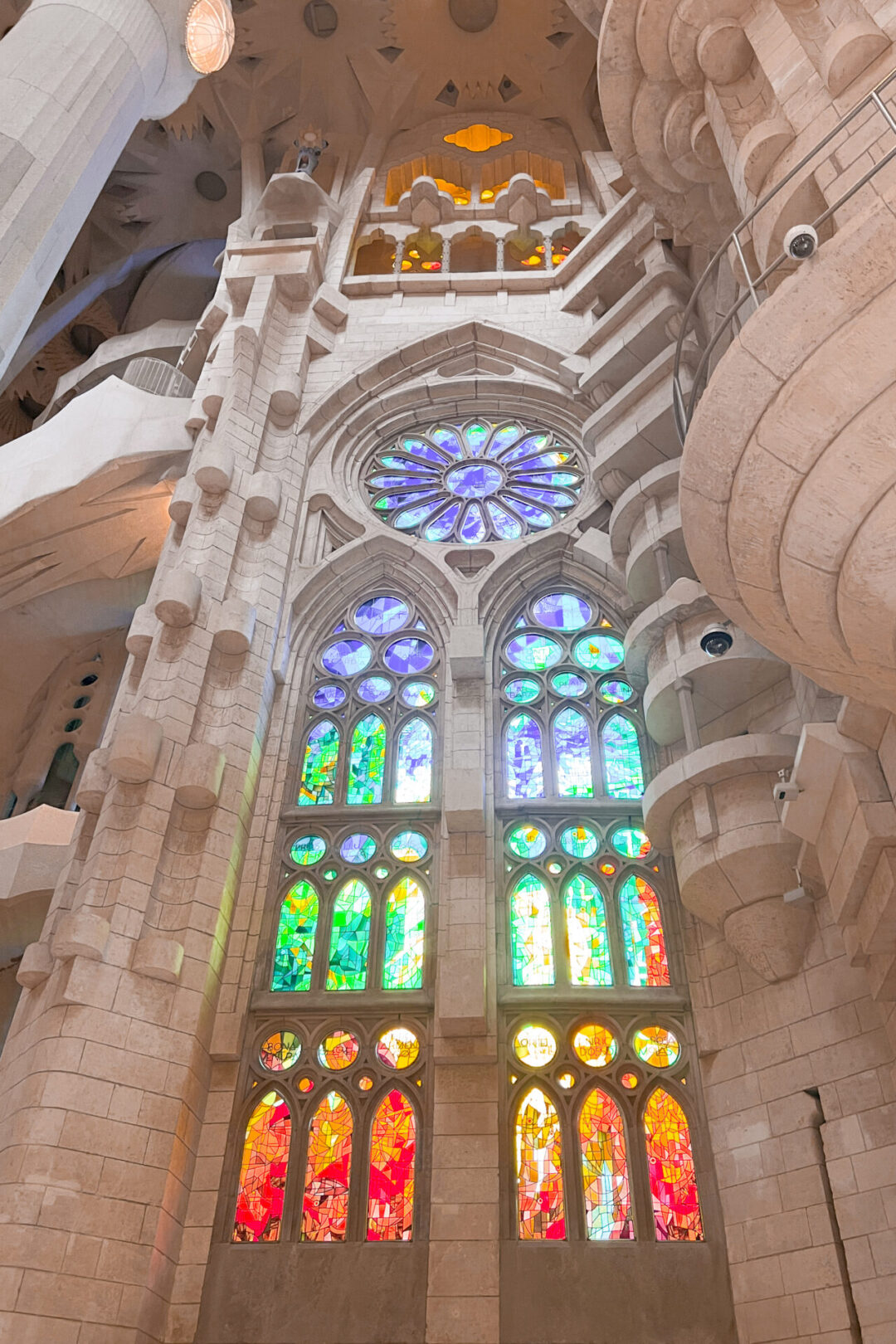 One of the stained glass windows casting rainbow glow throughout the interior of La Sagrada Familia in Barcelona, Spain
