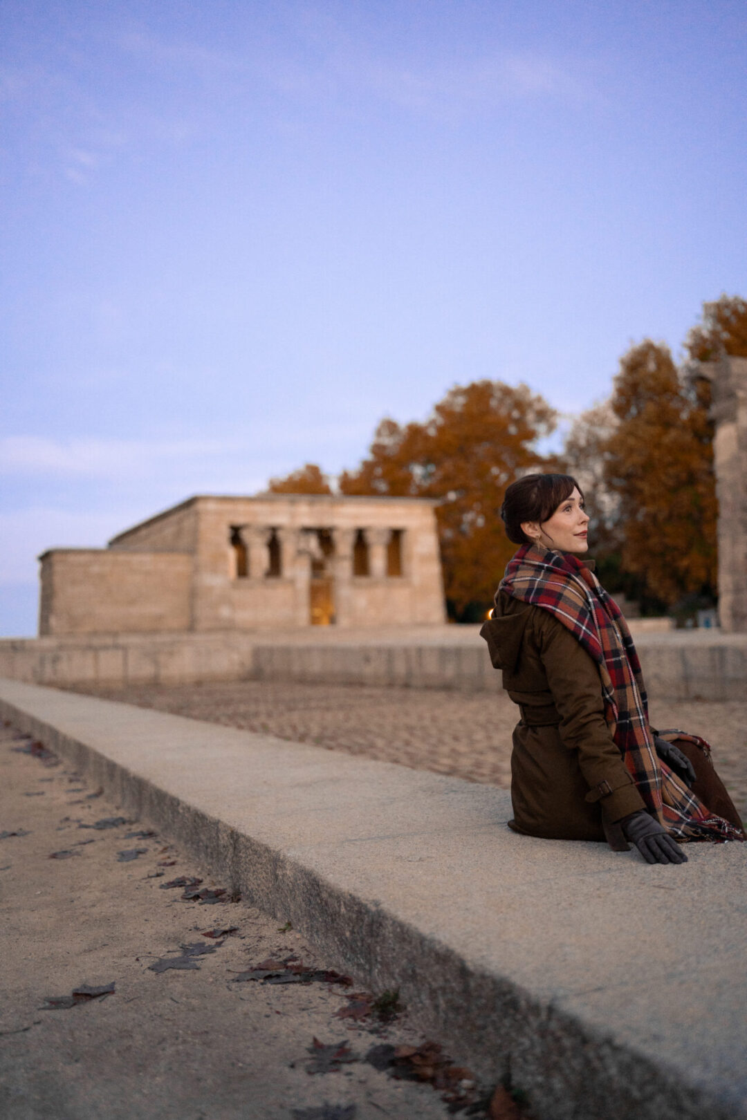 Travel Blogger Jordan Gassner sitting along the raised platform around Templo de Debod at sunrise in Madrid, Spain