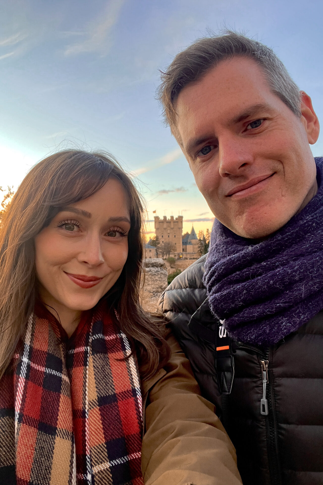 Travel Blogger Jordan Gassner and her partner taking a selfie with the Alcazar of Segovia in the background