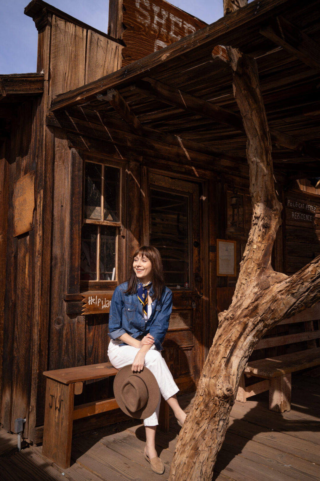 Travel Blogger Jordan Gassner sitting on a bench outside the Sheriff's Station at Calico Ghost Town in California