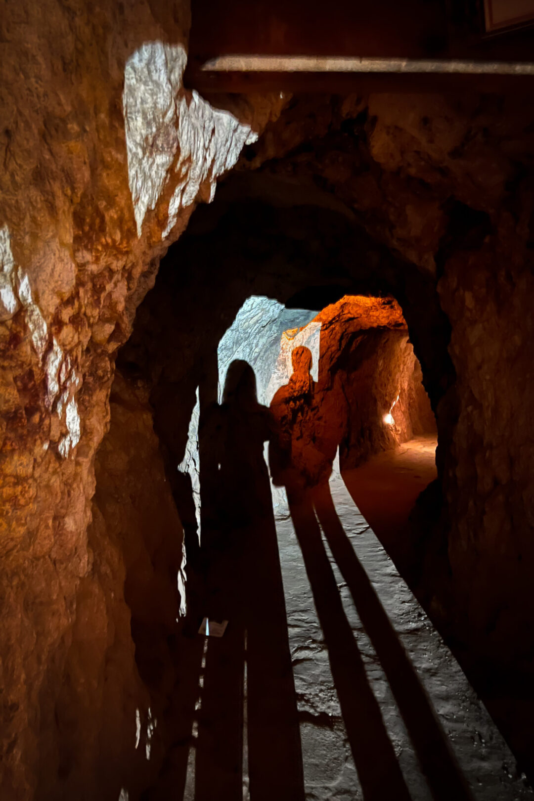 Travel Blogger Jordan Gassner and her partner standing inside a dimly lit tunnel at Calico Ghost Town's Maggie Mine in California