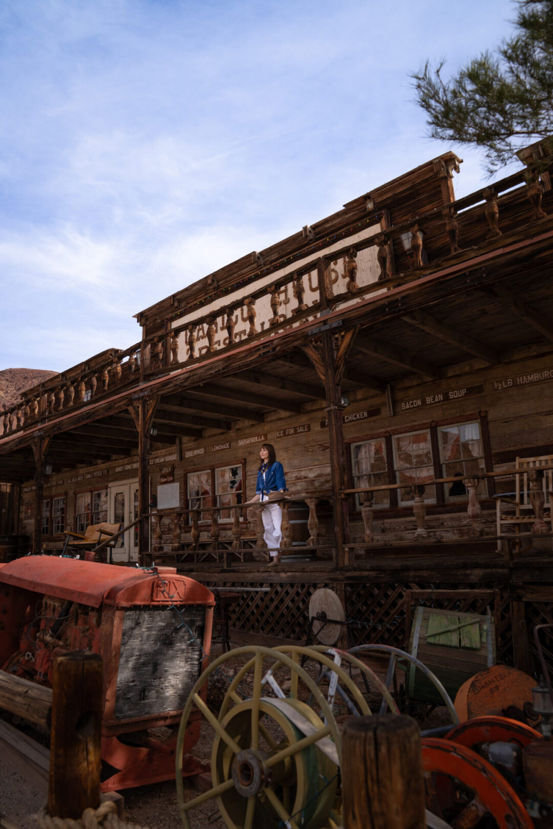 Travel Blogger Jordan Gassner leaning on the Calico House Restaurant railing at Calico Ghost Town in California