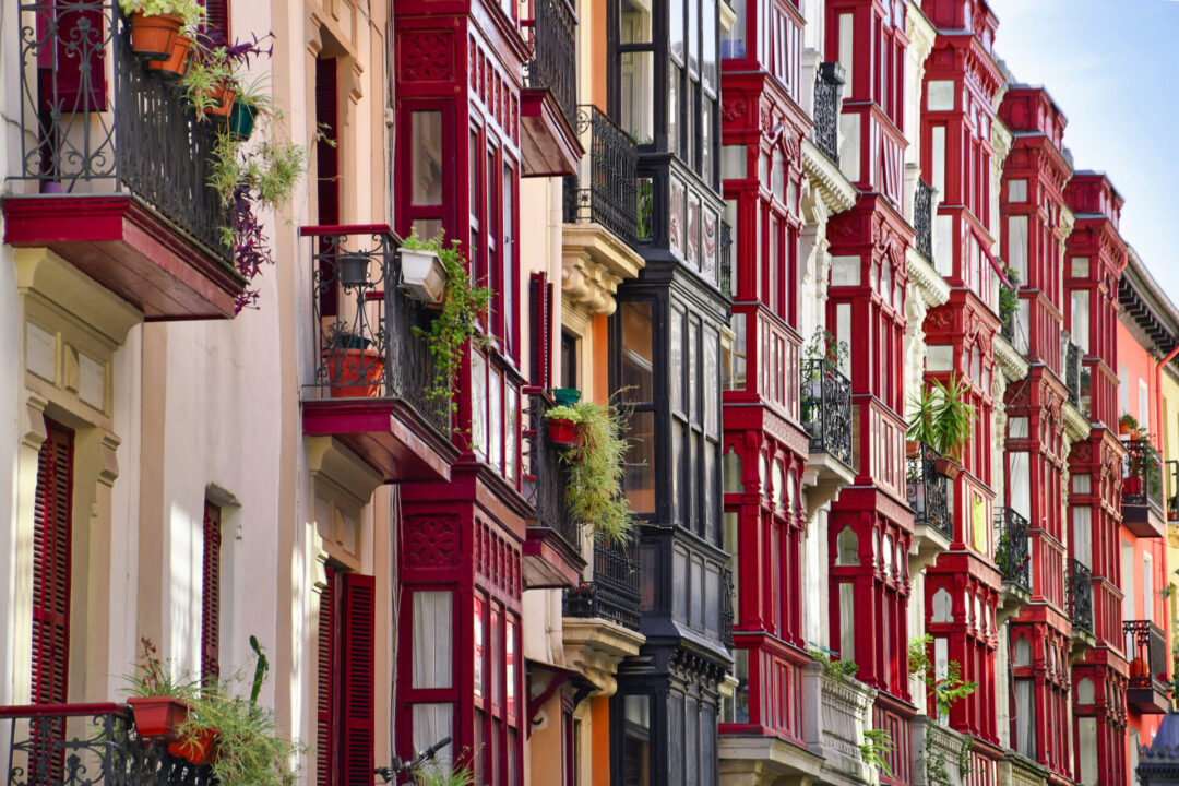 A series of burgundy, navy and canary yellow homes in Bilbao, Spain's old town