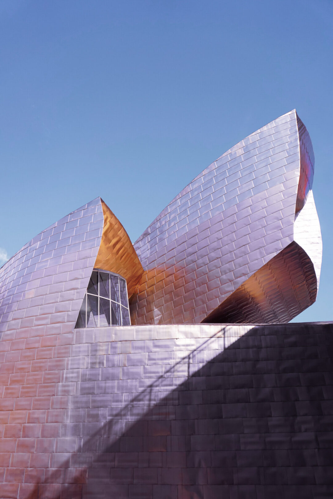 The normally silver Guggenheim building in Bilbao, Spain reflecting pink hues during the day