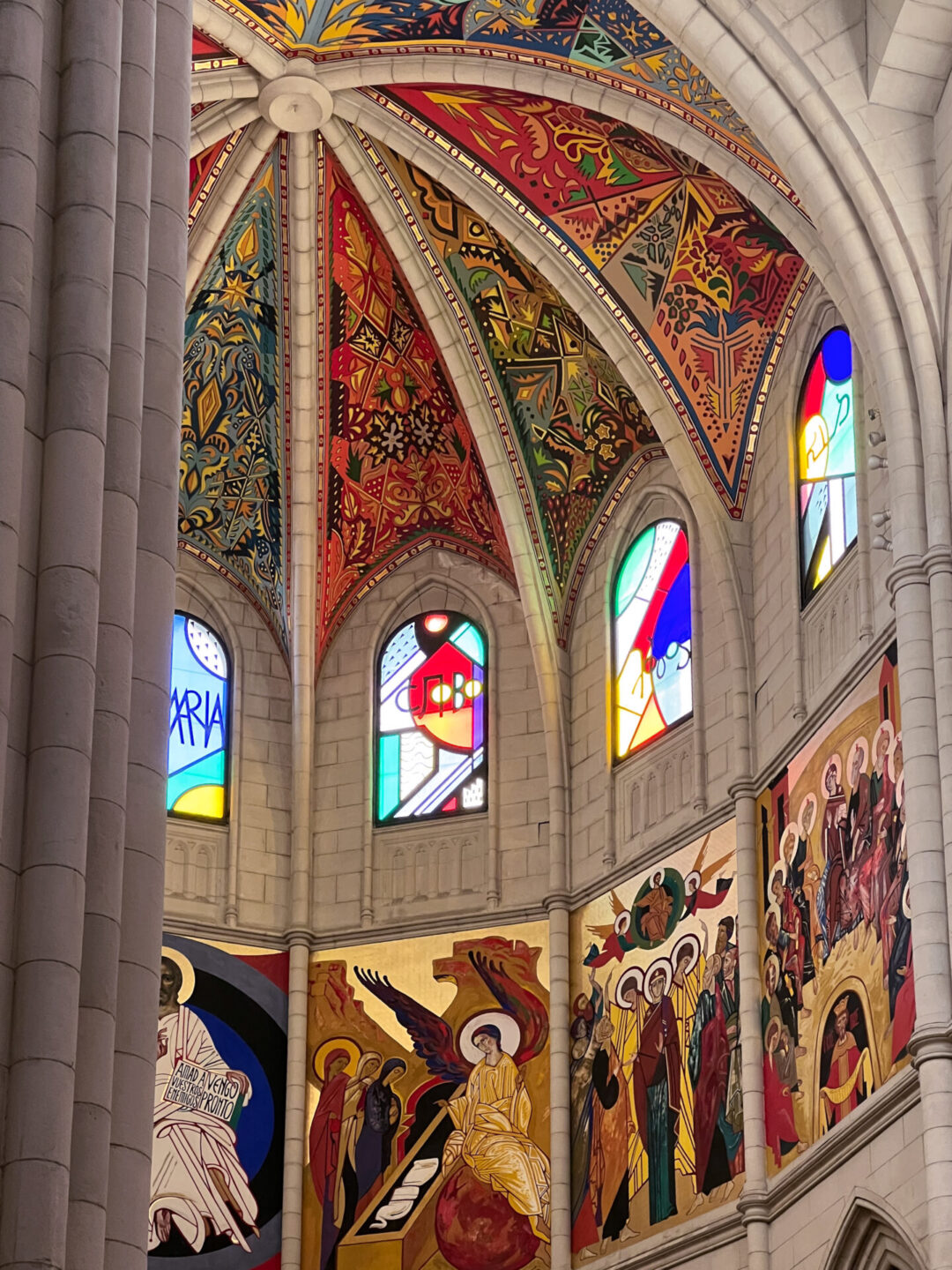 Colorful reliefs and stained glass adorning the ceiling of Almudena Cathedral in Madrid, Spain