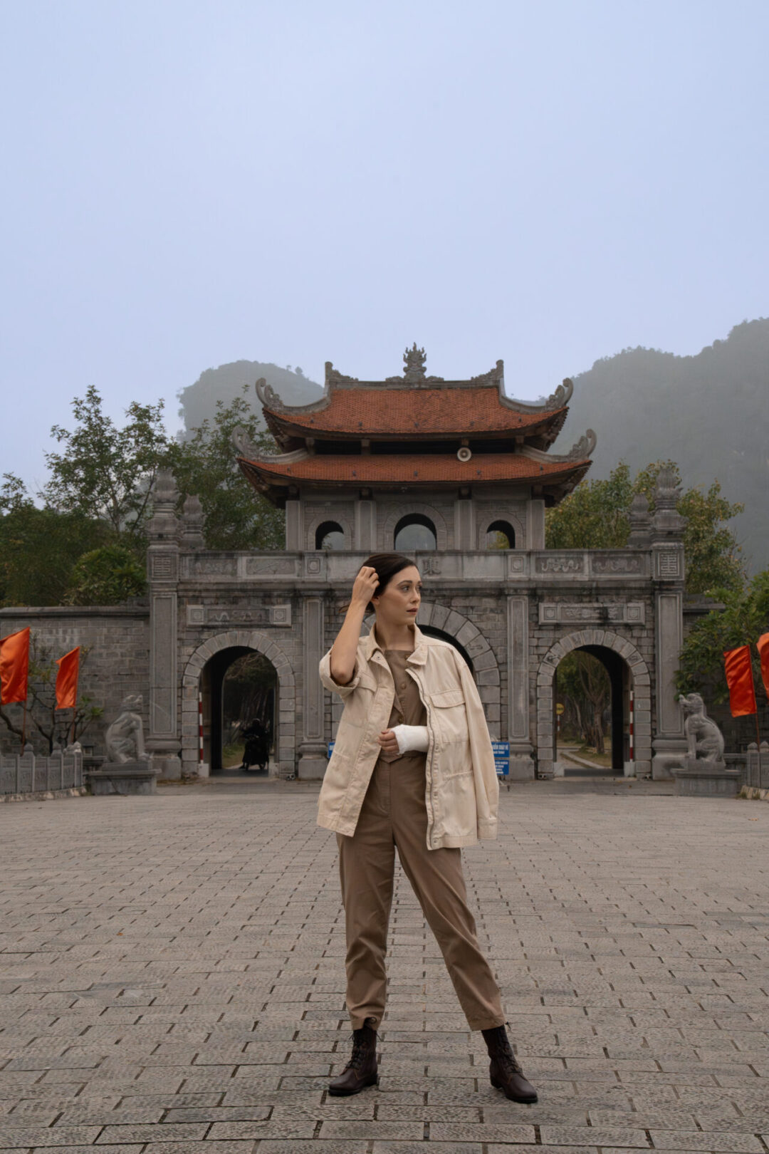 Travel Blogger Jordan Gassner standing on the bridge leading to the entrance of Hoa Lu Ancient Capital in Ninh Binh, Vietnam