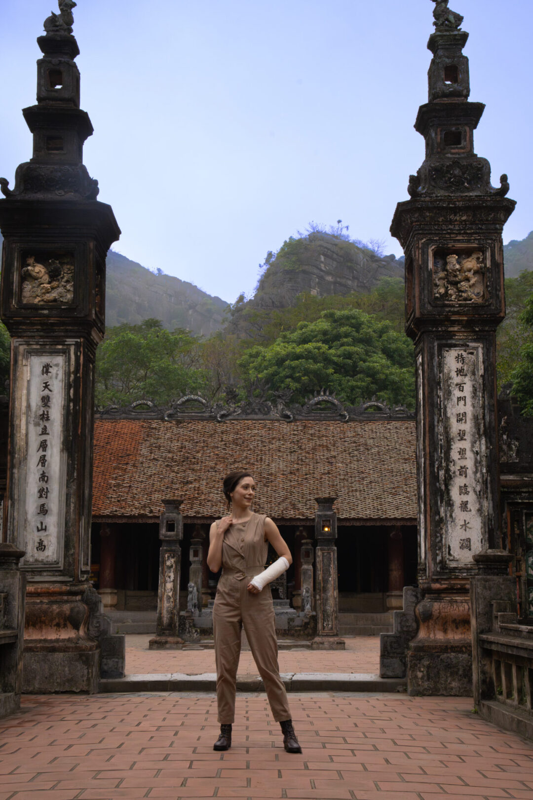 Travel Blogger Jordan Gassner smiling in front of a pagoda inside Hoa Lu Ancient Capital in Ninh Binh, Vietnam