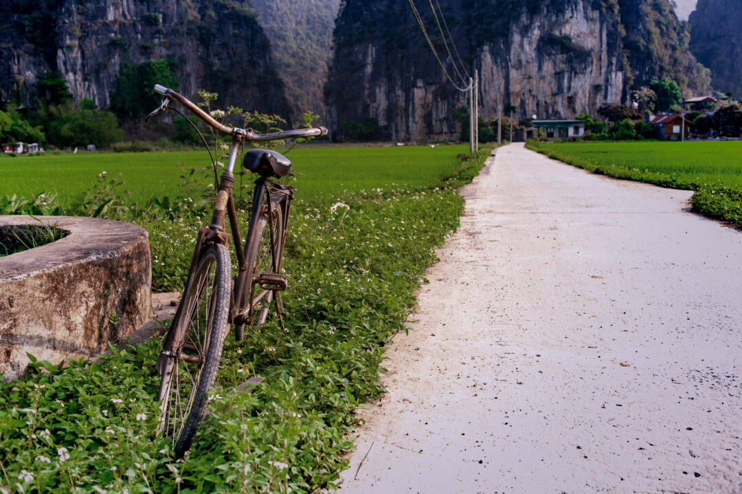 lone bicycle parked alongside a road in the paddy fields of Tam Coc, near Ninh Binh, Vietnam