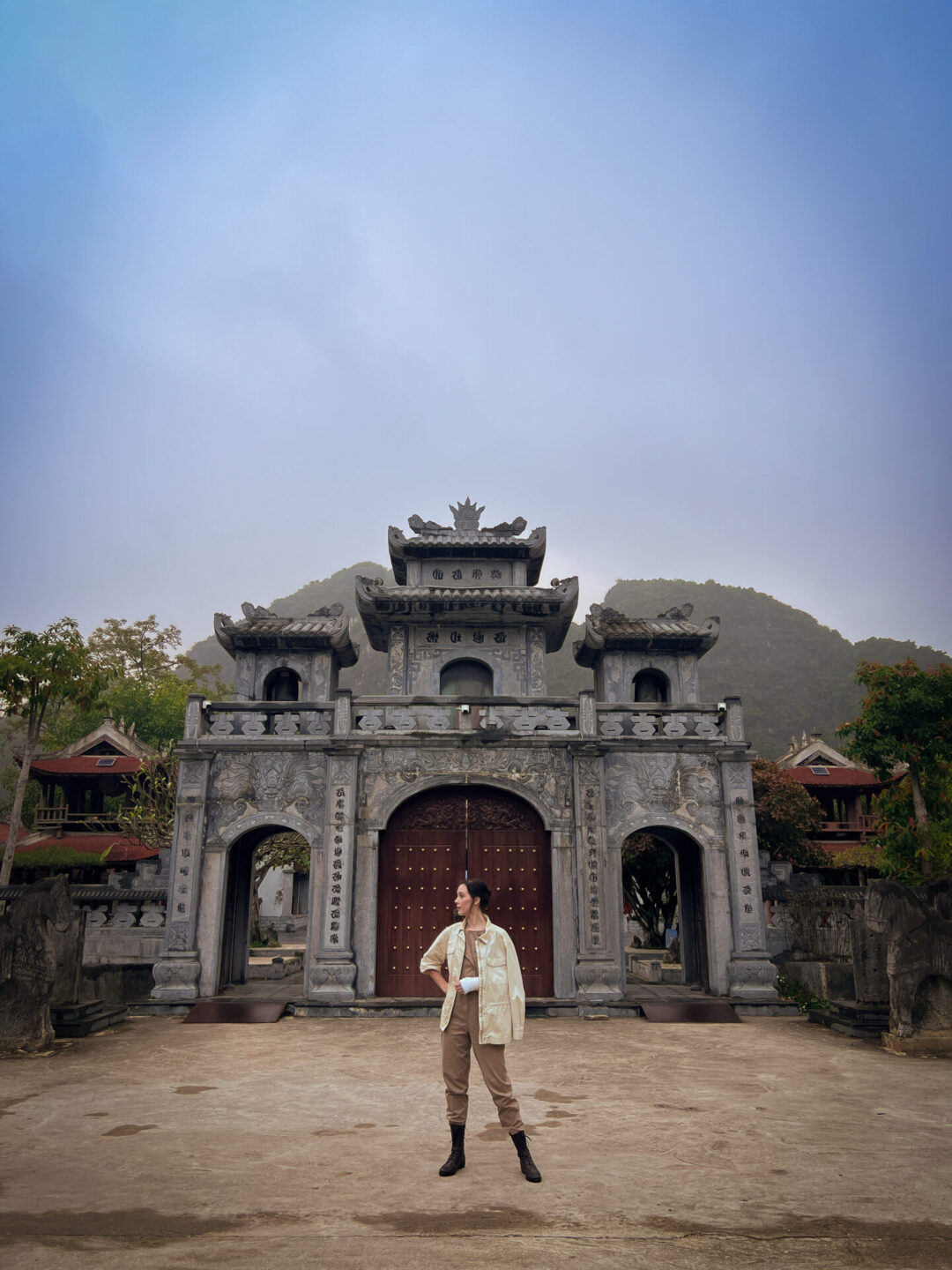 Things to do in Ninh Binh: Travel Blogger Jordan Gassner standing in front of the entrance at Thai Vi Temple in Ninh Binh, Vietnam