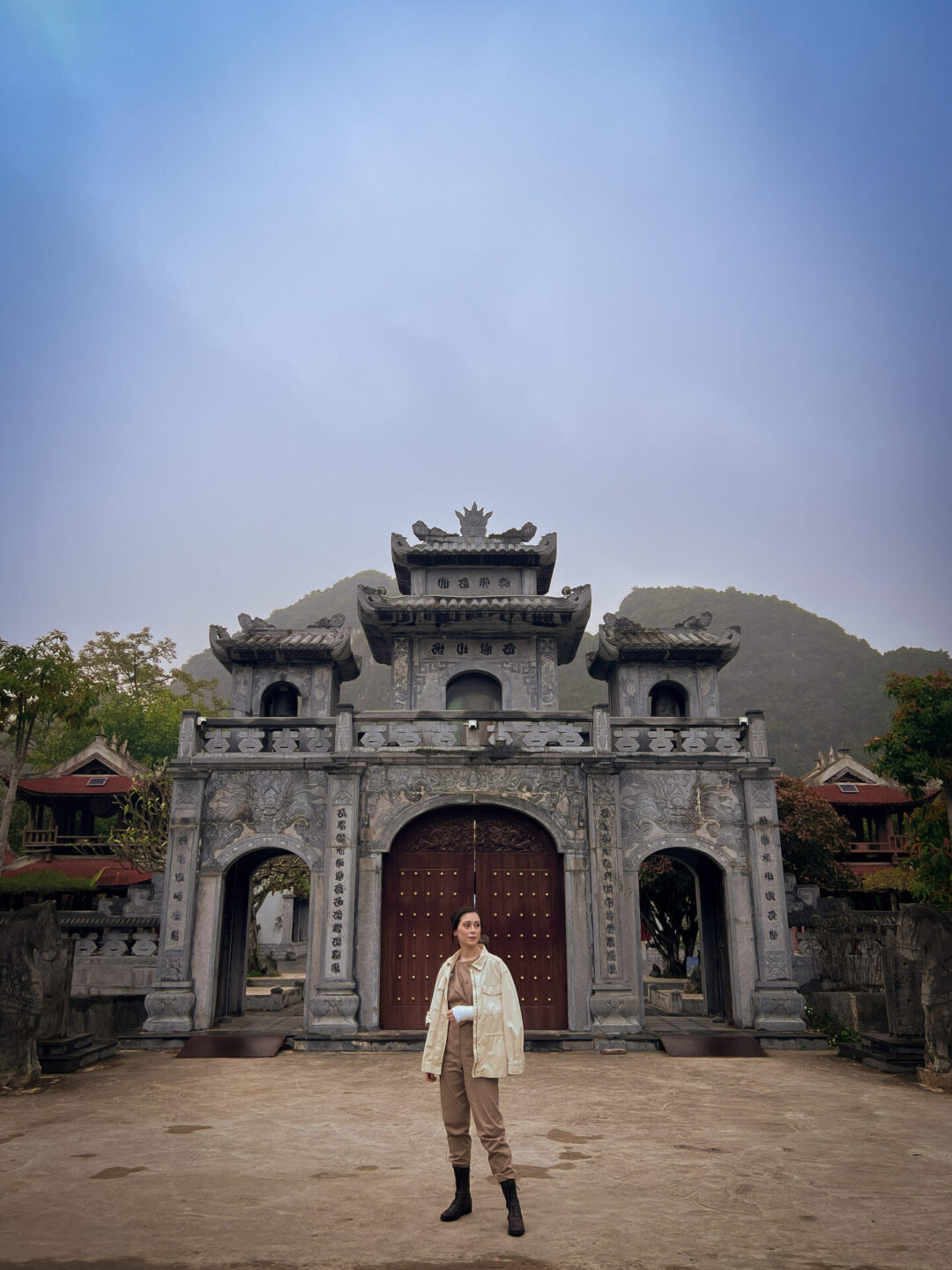 Travel Blogger Jordan Gassner looking around the entrance at Thai Vi Temple in Ninh Binh, Vietnam