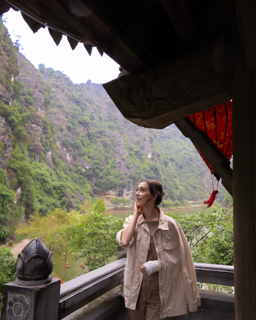 Travel Blogger Jordan Gassner looking up at the mountains from underneath a pagoda at Tuyet Tinh Coc in Ninh Binh, Vietnam