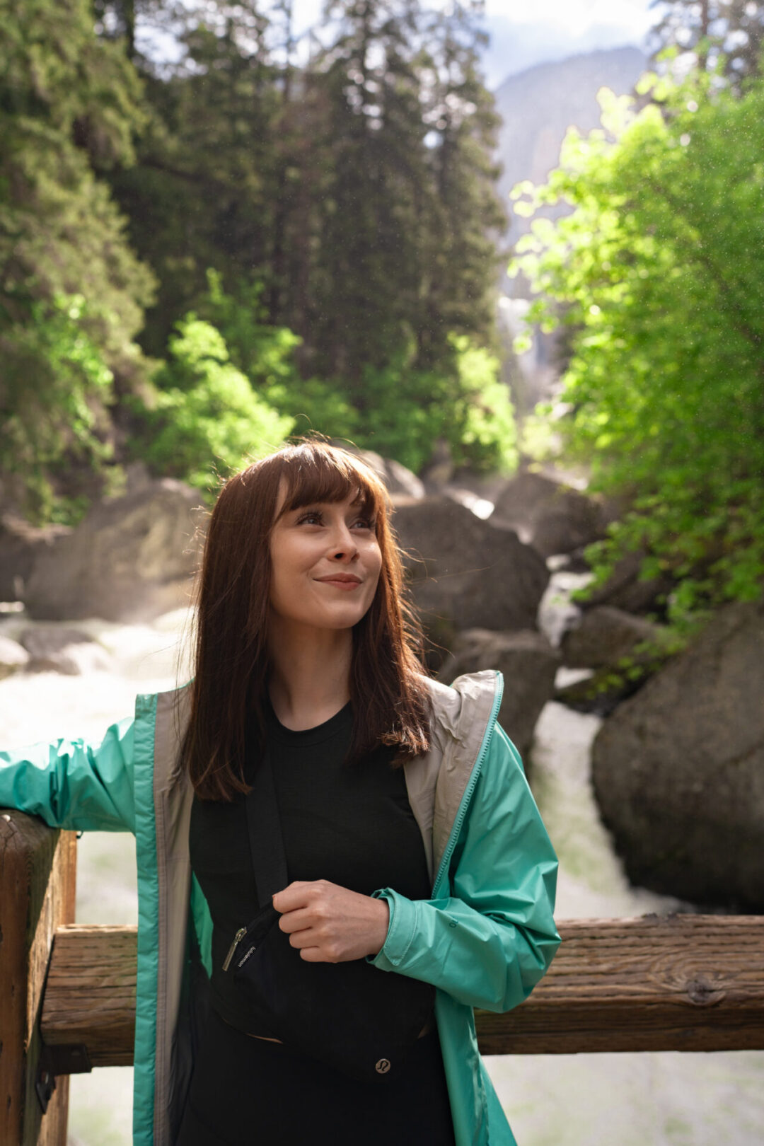Travel Blogger Jordan Gassner smiling along a wooden bridge along the Mist Trail in Yosemite National Park