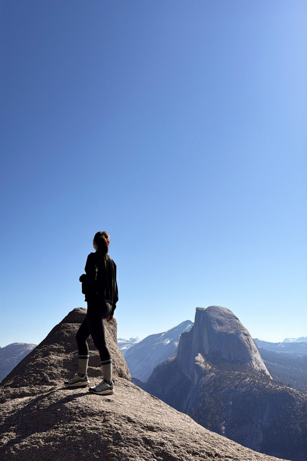 Travel Blogger Jordan Gassner looking out over Half Dome from Glacier Point in Yosemite National Park