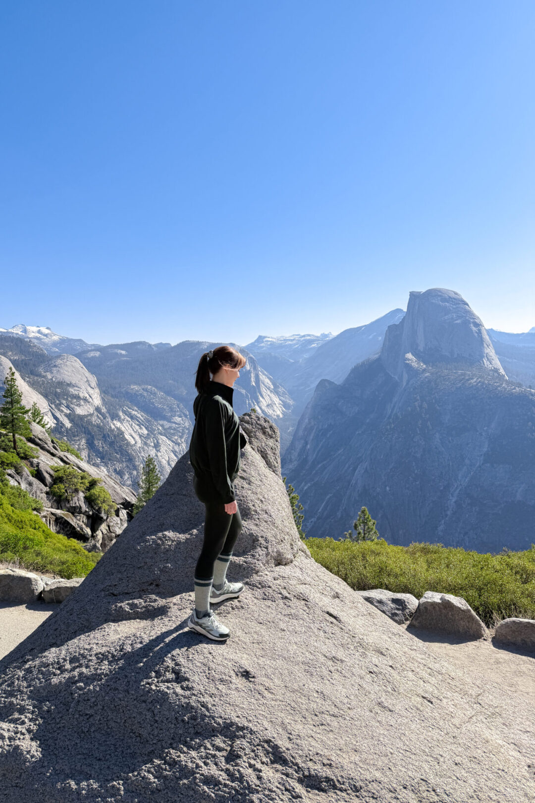 Travel Blogger Jordan Gassner looking down from a viepowint at Glacier Point on a Yosemite weekend trip