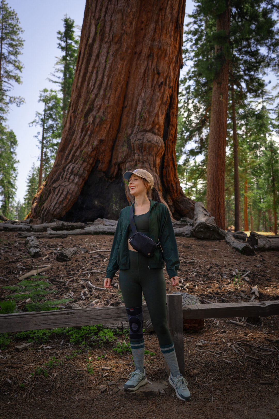 Travel Blogger Jordan Gassner smiling in front of the Grizzly Giant Sequoia inside Yosemite National Park in California, USA