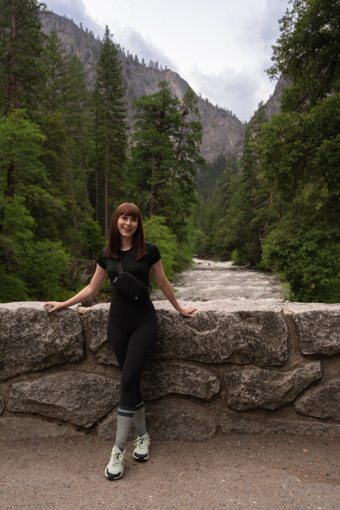 Travel Blogger Jordan Gassner smiling near a bridge at the start of the Mist Trail in Yosemite National Park