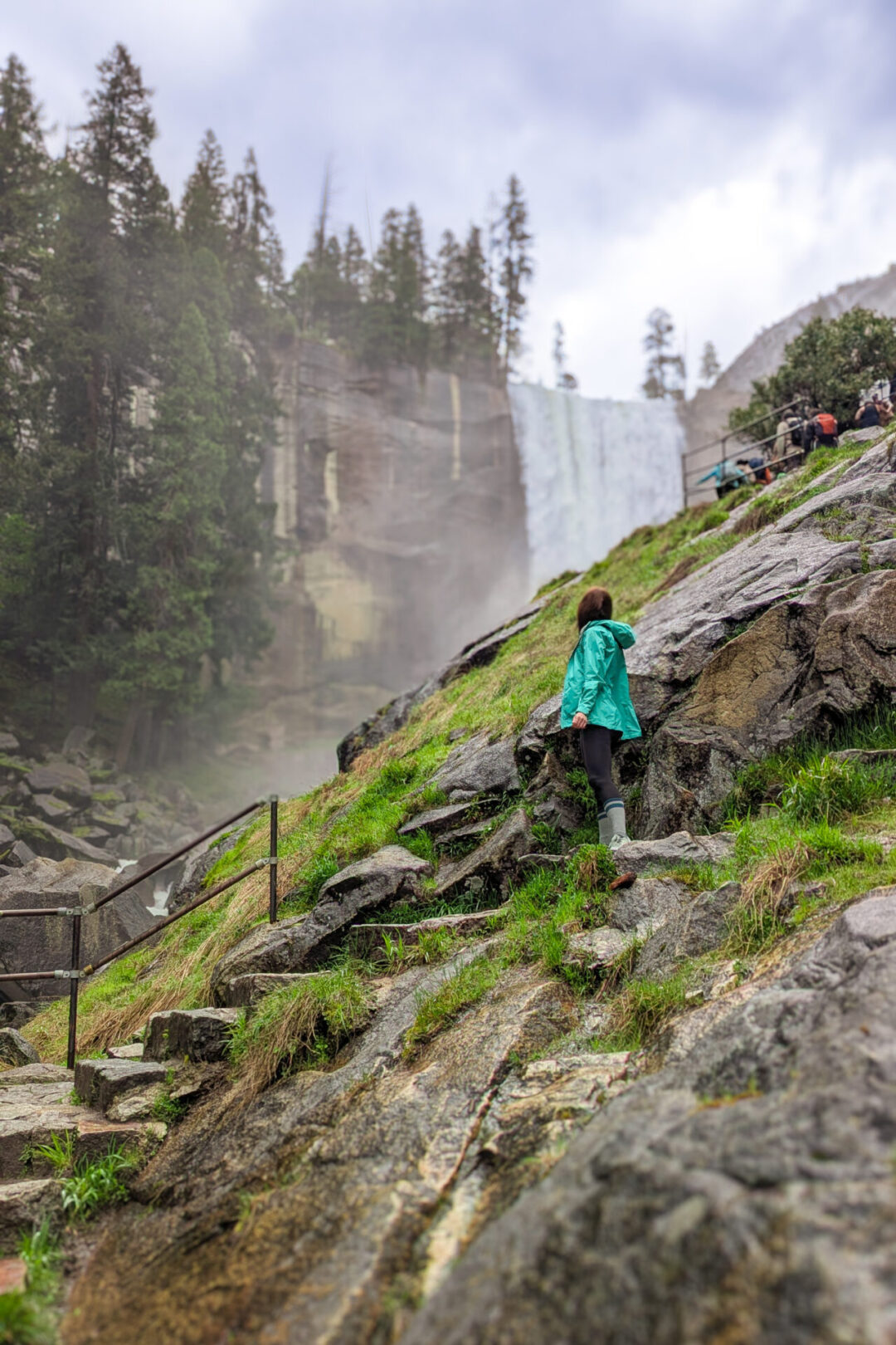 Travel Blogger Jordan Gassner looking up at Nevada Falls along the Mist Trail in Yosemite National Park, California, USA