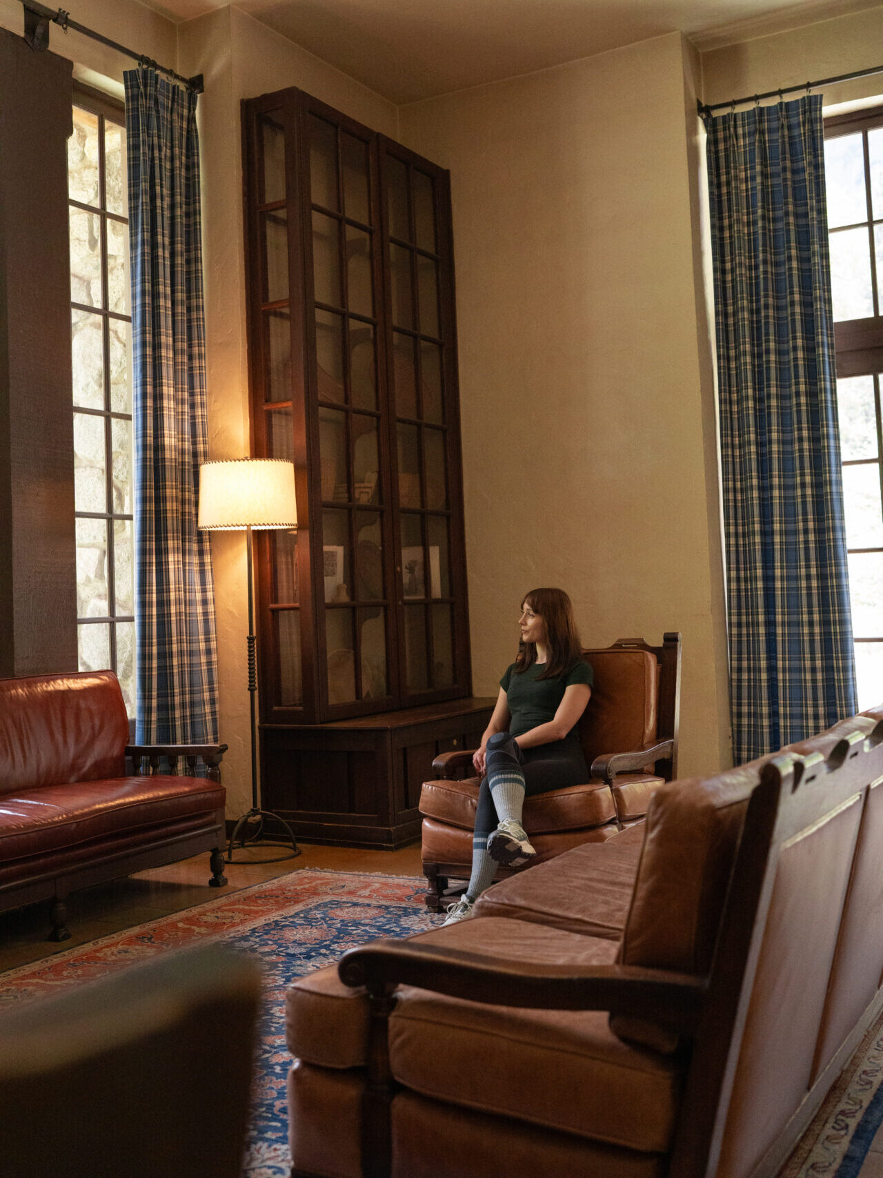 Travel Blogger Jordan Gassner sitting inside an empty living room at the Ahwahnee Hotel, a five star property in Yosemite National Park
