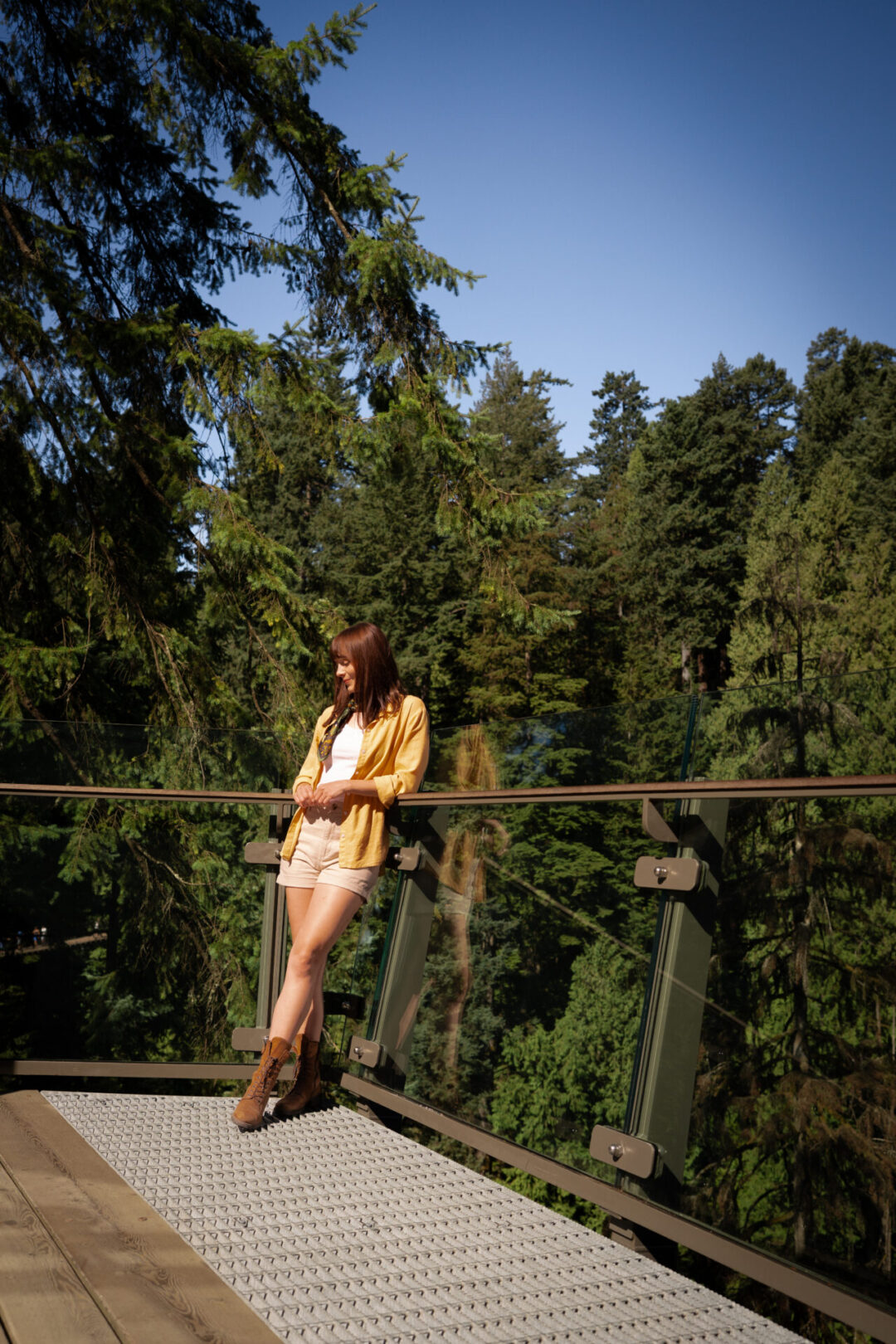 Vancouver Neighborhoods: Travel Blogger Jordan Gassner leaning against a viewing platform in Capilano Suspension Bridge Park in North Vancouver