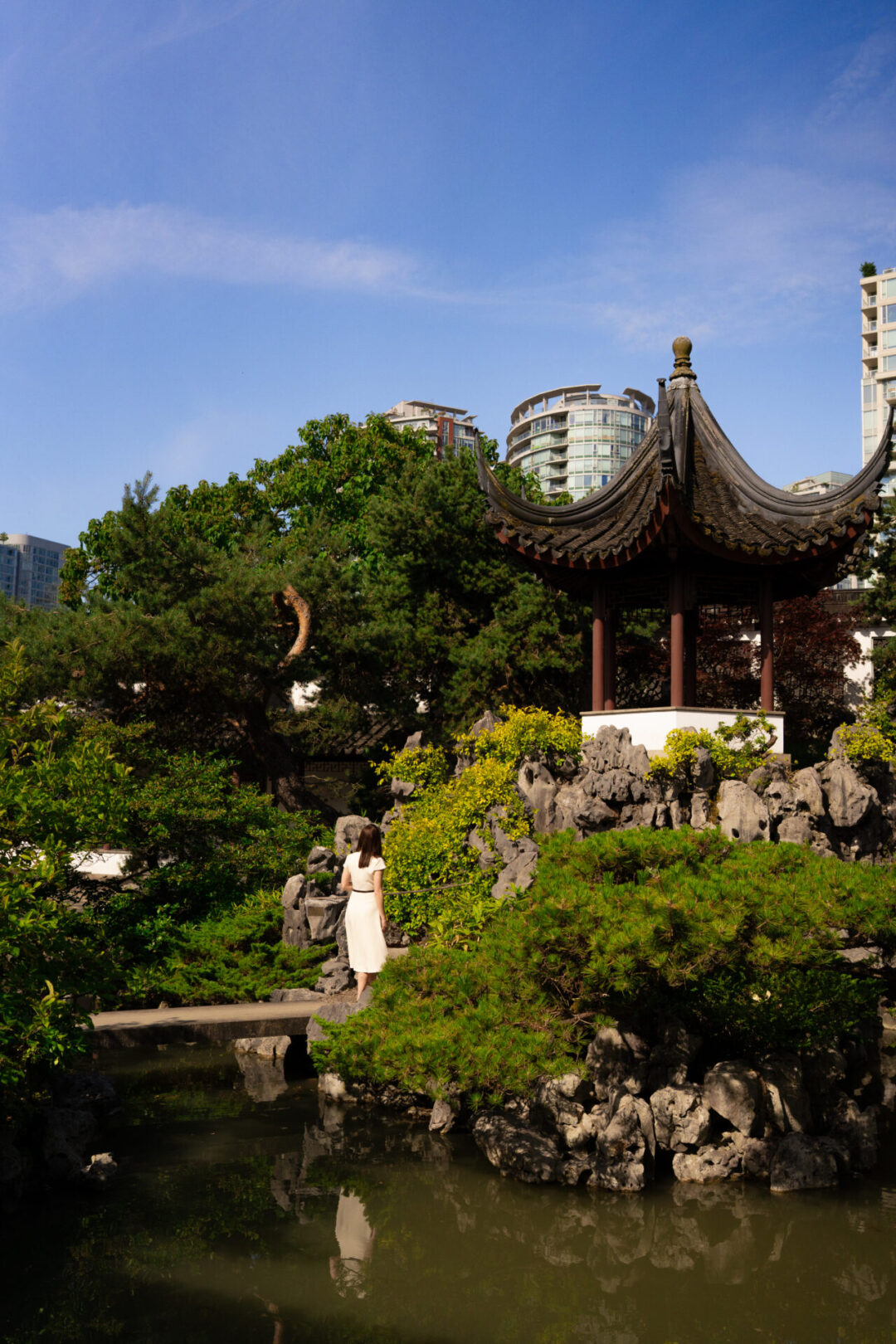 Travel Blogger Jordan Gassner walking along a bridge within the Dr. Sun Yat-Sen Classical Chinese Garden in Chinatown in Vancouver, Canada