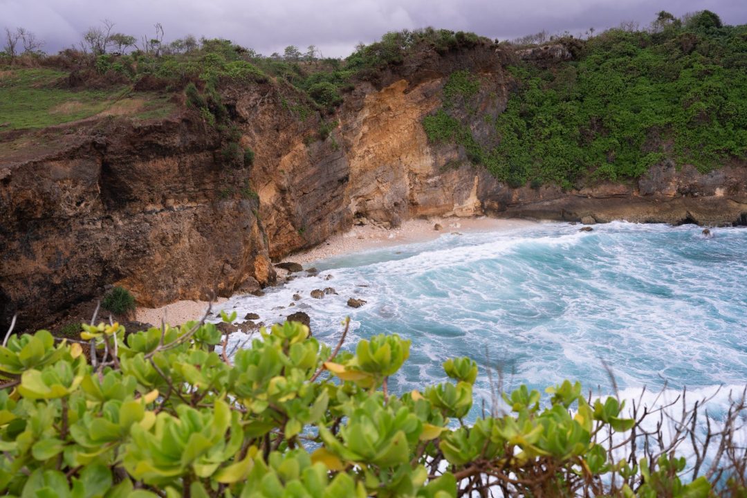 Turquoise waves hitting the beach from the Mareha Cape viewpoint in Sumba, Indonesia